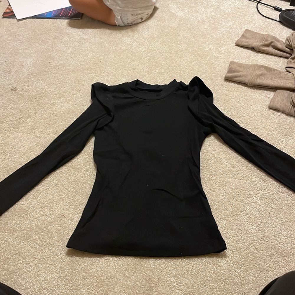 Black shirt with a ruffle sleeve on the shoulder